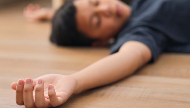 Closeup,Hand,Of,Unconscious,Kid,Lying,On,The,Floor,At